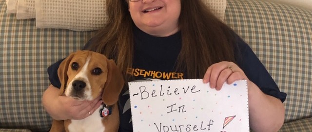 School nurse with sign that reads, "Believe in yourself. We believe in you!"